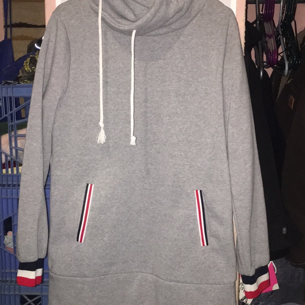 Grey sweater with red, white, blue pockets.